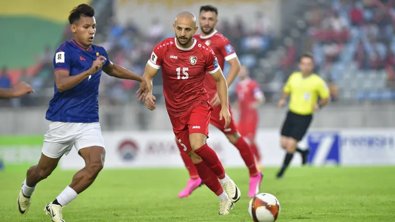 Cầu thủ Myanmar đi bóng qua cầu thủ Syria trong trận đấu bóng đá quốc tế Cầu thủ Myanmar đi bóng qua cầu thủ Syria trong trận đấu bóng đá quốc tế