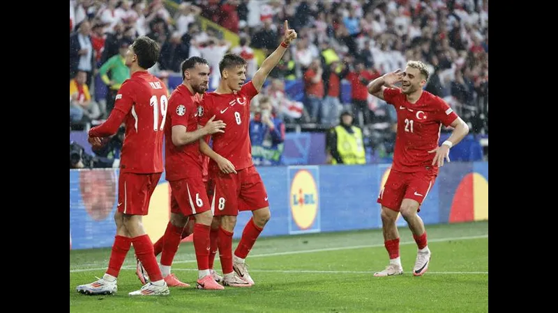 Cầu thủ Thổ Nhĩ Kỳ dũng mãnh vượt qua sự truy đuổi của cầu thủ Georgia trên sân cỏ